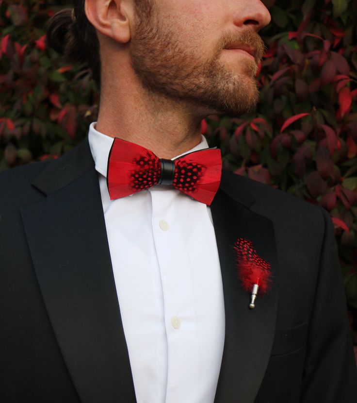 The Jaxon Feather bow tie is a classic red and black tie that will keep it sharp and your look formally fresh. It is a classic, understated, and unique groom's tie. Perfect for weddings and special events. An absolute must-have bow tie to add to your collection. This sleek red tie also comes in children's sizes so your groomsmen and ring bearer bow ties can match! Every Feather Bow Ties Comes with: Beautiful, Hand-Crafted, High Quality Feather Bow Tie, with an adjustable strap that can fit up to Red Bow Standard Bow Tie For Party, Red Bow Tie For Party, Fitted Red Bow Tie For Black Tie Events, Classic Red Bow For Black Tie Events, Classic Red Bow Tie For Formal Occasions, Dapper Tuxedo With Bow Tie For Black Tie Events, Adjustable Red Suit And Tie Accessories For Wedding, Elegant Red Bow Tie Adjustable, Elegant Adjustable Red Bow Tie