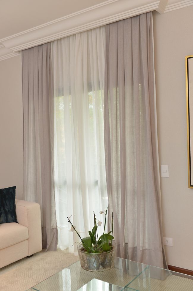 a living room with a couch, coffee table and curtains