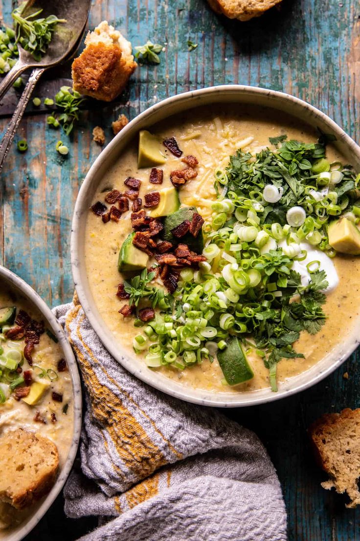 two bowls of soup with bread on the side