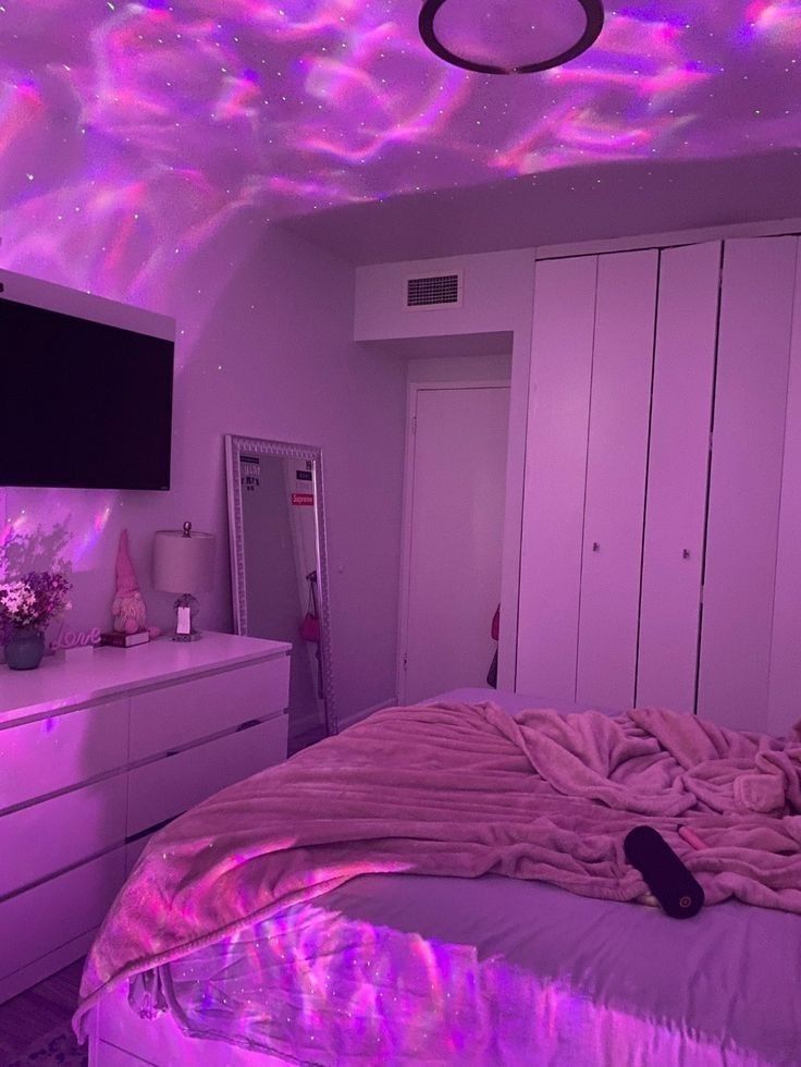 a bedroom with purple lights on the ceiling