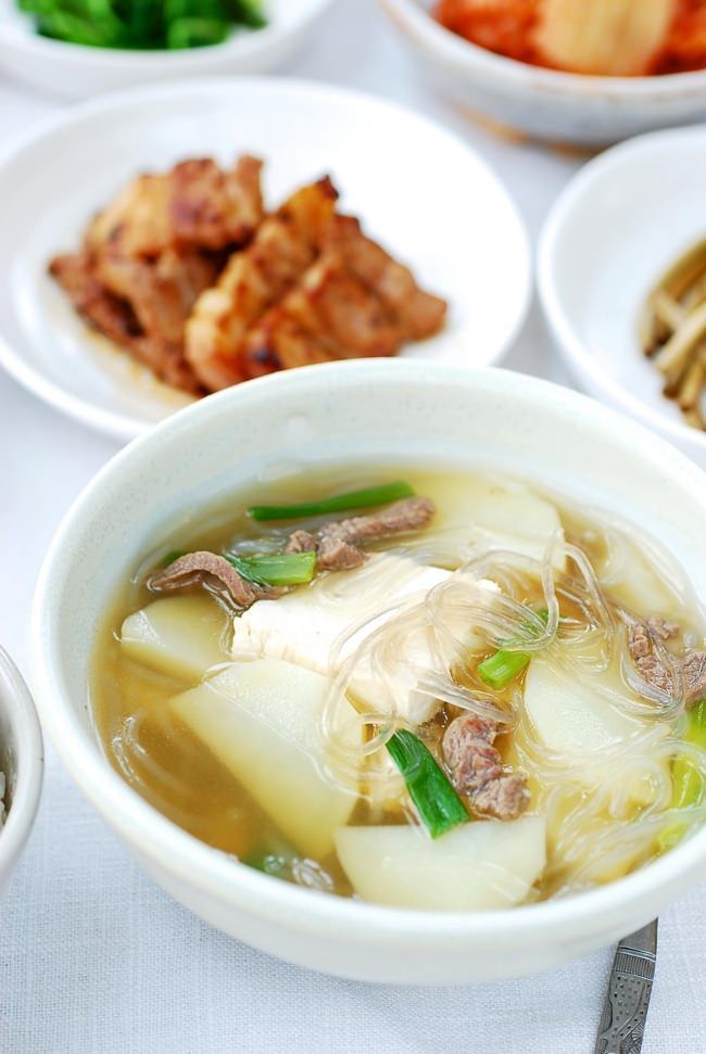 a table topped with white bowls filled with soup