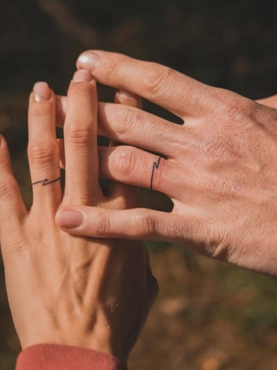 two people holding each other's hands with their fingers