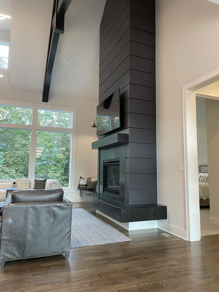 a living room with a couch, chair and fireplace in the middle of the room