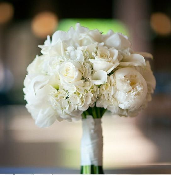 a bouquet of white flowers sitting on top of a wooden table next to an instagram page