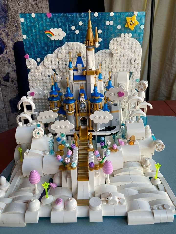 a lego castle with lots of white and blue decorations on it's sides, surrounded by other toys