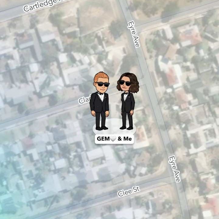 two people in suits and sunglasses standing next to each other on top of a map