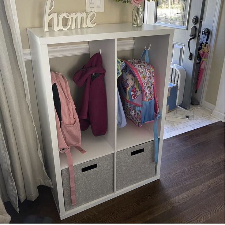 a white shelf filled with lots of items next to a door