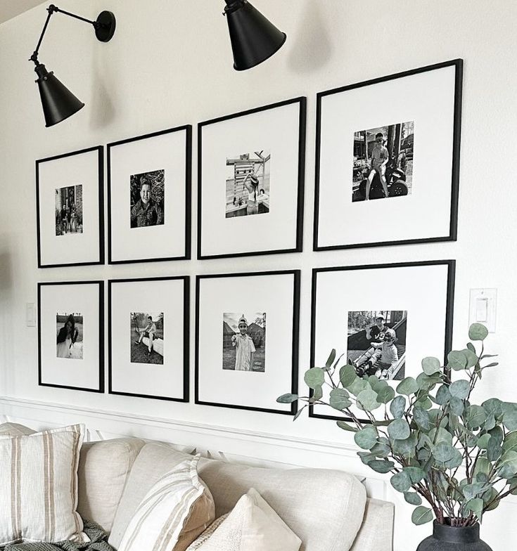 a living room with pictures hanging on the wall and a couch in front of it