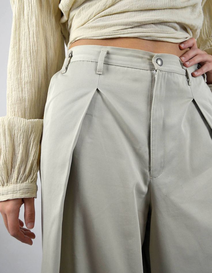 Made in FranceProduct description :- High-waisted beige pant,- With symmetrical pleats on each side,- Fly and Italian pockets,- Zipper closure and black metallic press.Future partner of daily life, the Palmo Pant will accompany you with comfort and style. Palmo is beige culotte-style trousers, a timeless and essential piece for a minimalist wardrobe. Cut in beige cotton twill from the end of the rolls of a major luxury brand, its simplicity and ease go perfectly with the Bhuti Shirt, for a clean Beige Wide-leg Workwear Parachute Pants, Beige Wide-leg Parachute Pants For Work, Modern Beige Bottoms With Pockets, Beige Pleated Straight Pants, Spring Pleated Khaki Bottoms, Beige High-waisted Pleated Pants, Pleated Khaki Bottoms For Fall, Khaki Pleated Bottoms For Fall, Fall Pleated Khaki Bottoms