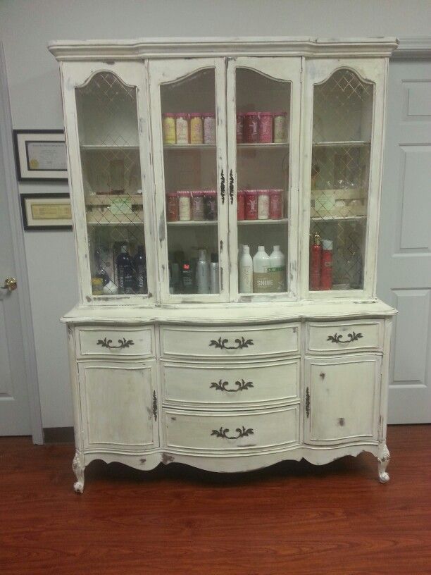 an old white china cabinet with glass doors