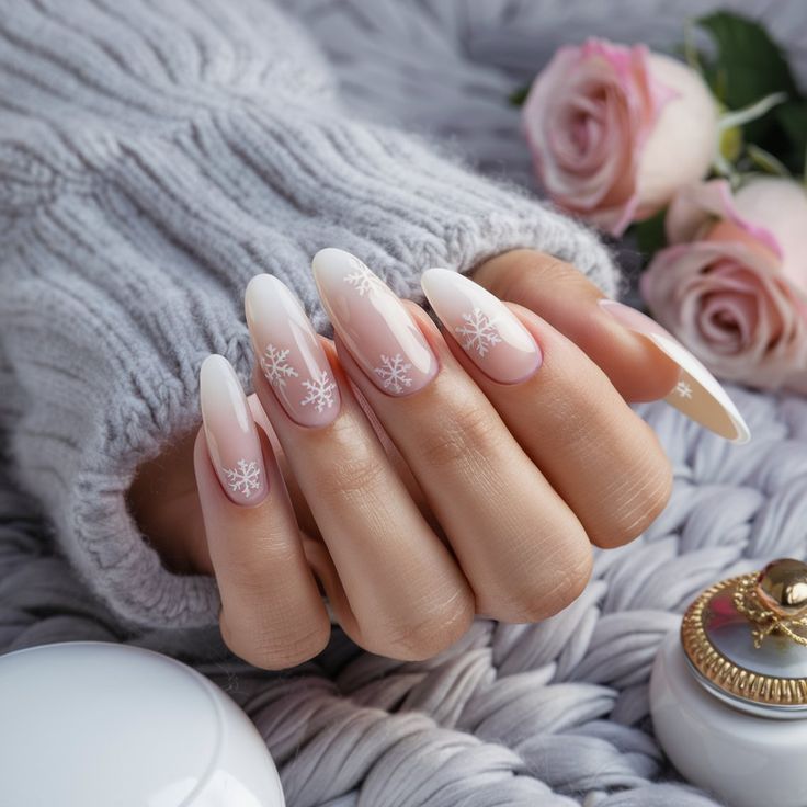 Featuring a nude pink base with delicate white snowflakes, this manicure is the epitome of winter elegance. The soft almond shape adds a subtle touch of sophistication, while the simple snowflake details create a beautiful and refined winter look. Ideal for those who love understated yet seasonal designs that are perfect for everyday wear during the colder months. Almond Snowflake Nails, Snowflake Nails Simple, Simple Snowflake, Winter Nails Acrylic, Snowflake Nails, Almond Shape, Nails Simple, White Snowflake, Nude Pink