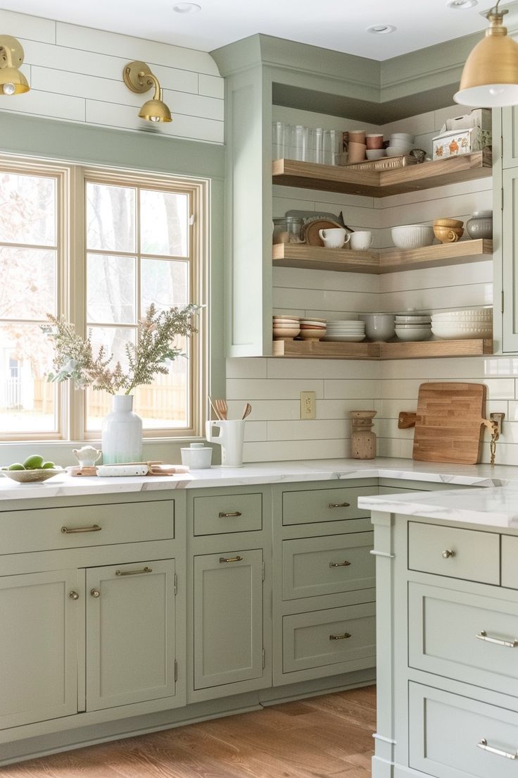 a kitchen with green cabinets and white counter tops in the center, along with open shelving