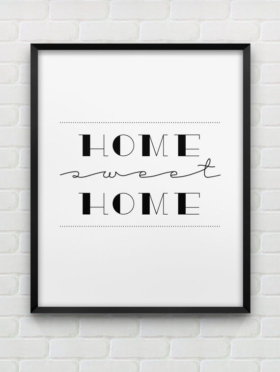 a framed black and white poster with the words home sweet home on it in front of a brick wall