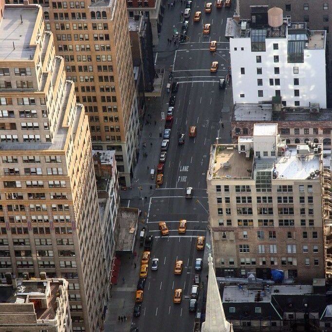 an aerial view of a city with tall buildings and cars on the street in front of them