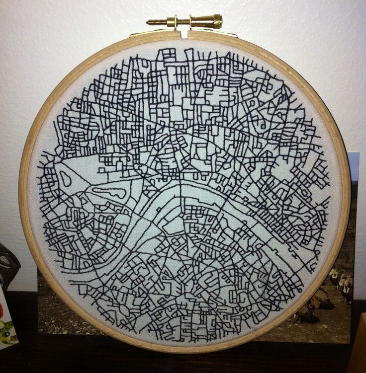 a cross stitch map is hanging on the wall