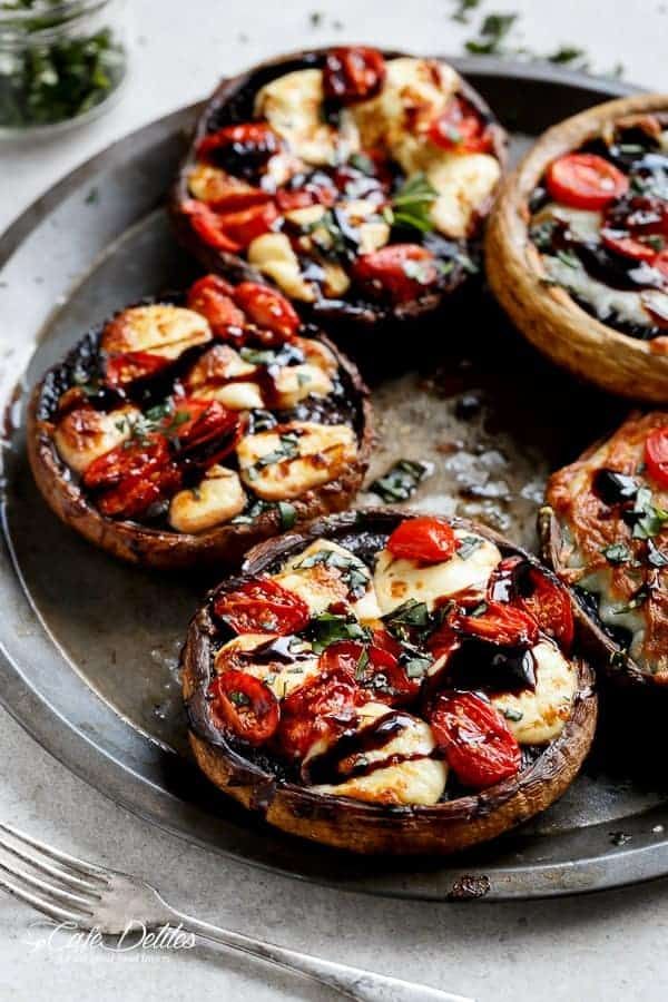 baked mushrooms with tomatoes and cheese on a plate