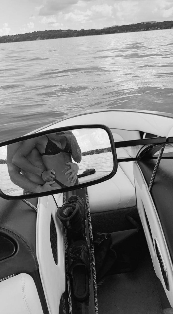 a man sitting on the back of a boat in front of a mirror