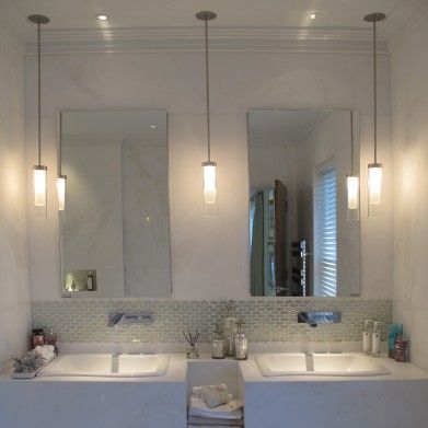 a bathroom with two sinks and three lights on the wall above them is shown in this image