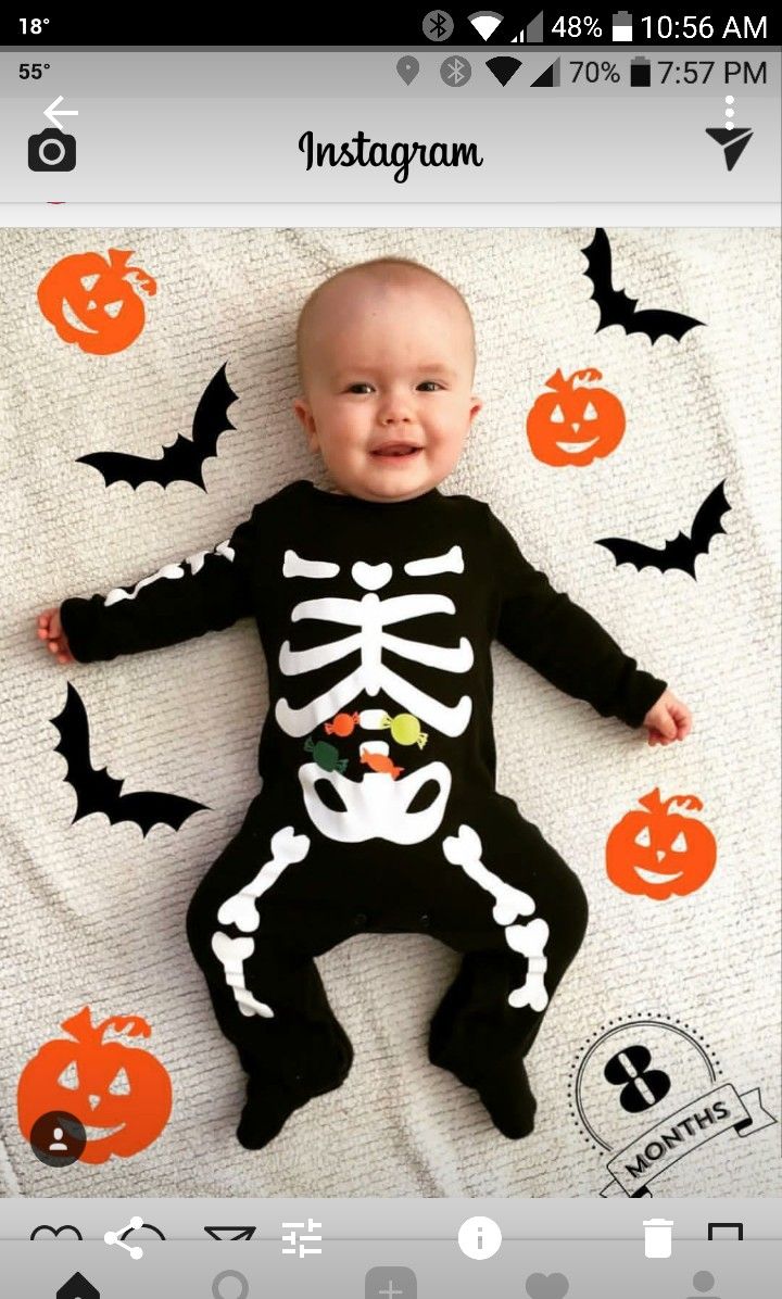 a baby laying on top of a blanket covered in halloween decorations