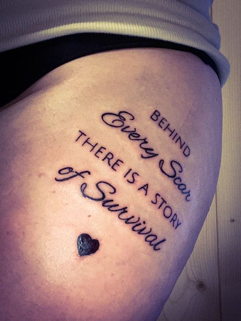 a woman's thigh with the words behind her and there is a stone in the shape of a heart