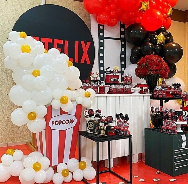 a room filled with balloons and decorations for a movie party