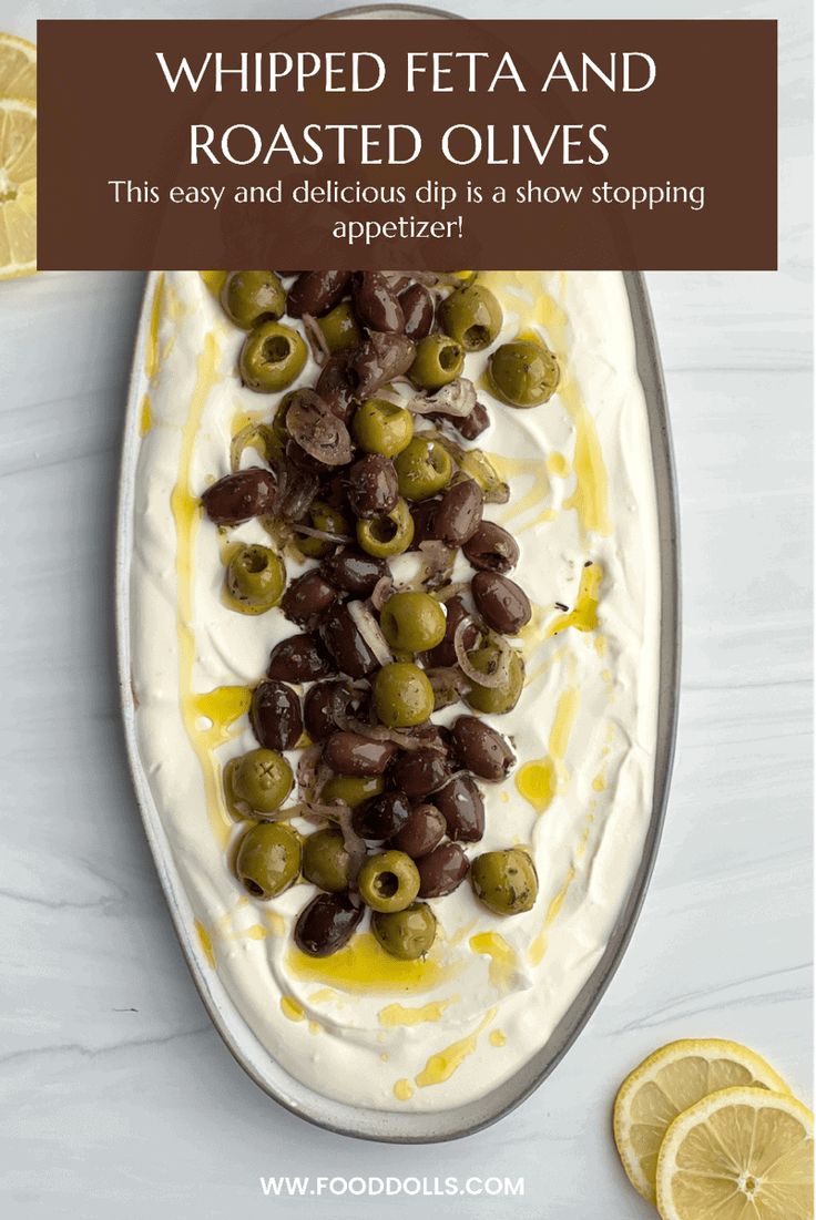 olives and whipped cream on a platter with lemon slices