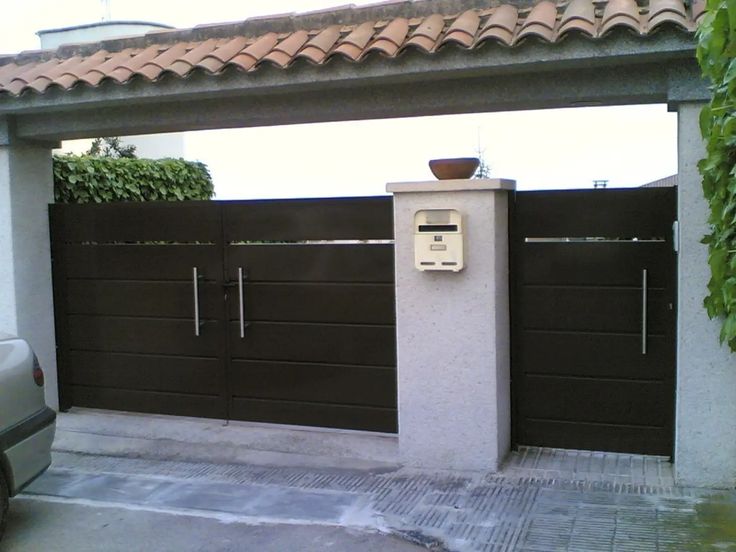 an image of a mailbox in front of a gated area with a planter