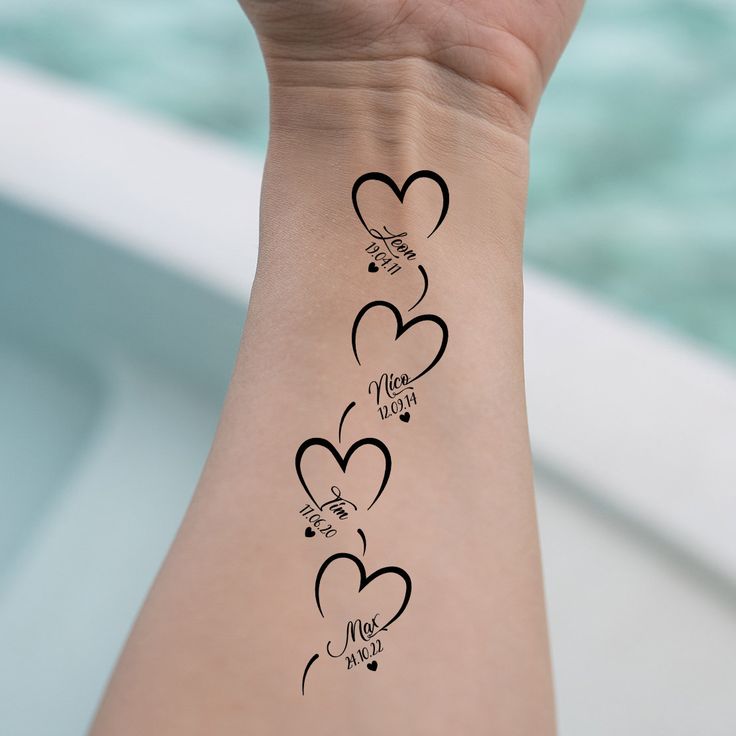 a woman's arm with three hearts on it and the words love is written in cursive writing