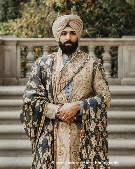 a man wearing a turban and standing in front of some steps with his arms crossed