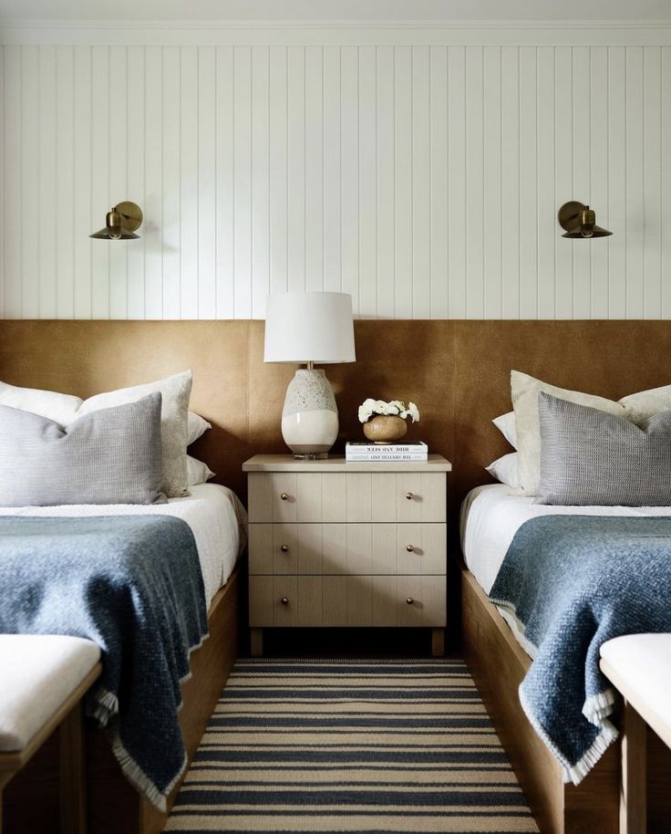 two beds in a bedroom with blue and white bedding