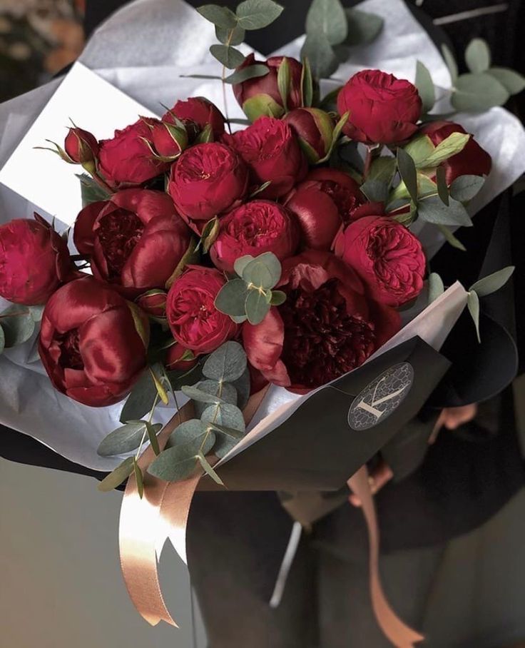 a bouquet of red roses is wrapped in paper