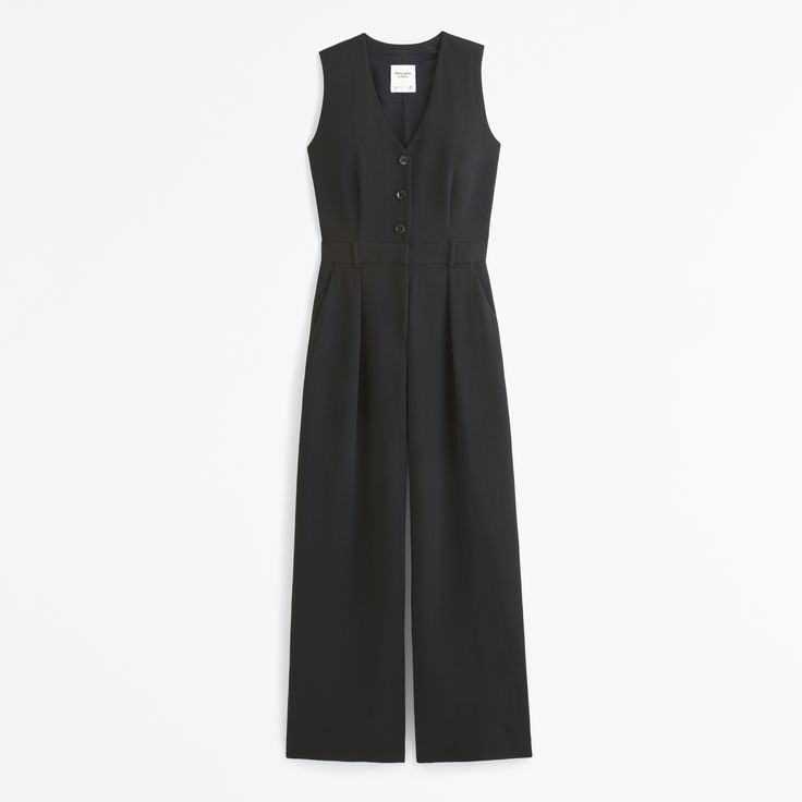 Our versatile vest jumpsuit in our soft crepe fabric, featuring a button-through detail, v-neckline, back zipper closure and a belted waist. Elegant V-neck Jumpsuits And Rompers For Daywear, Fitted V-neck Jumpsuits And Rompers With Buttons, Elegant V-neck Jumpsuit Or Romper With Buttons, Fitted V-neck Jumpsuit With Button Closure, Medium Wash Button-up Jumpsuits With Pockets, Black V-neck Jumpsuit With Pockets, Crepe Fabric, Athletic Fits, New Arrival Dress