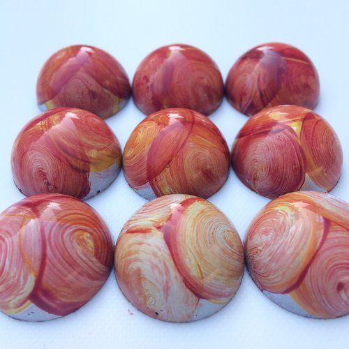 six red and yellow marbles on a white surface