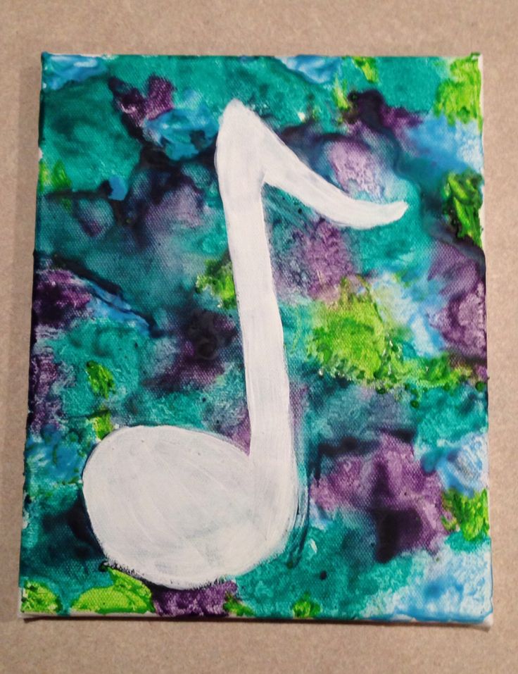 a piece of art that looks like a white music note on green and purple paper