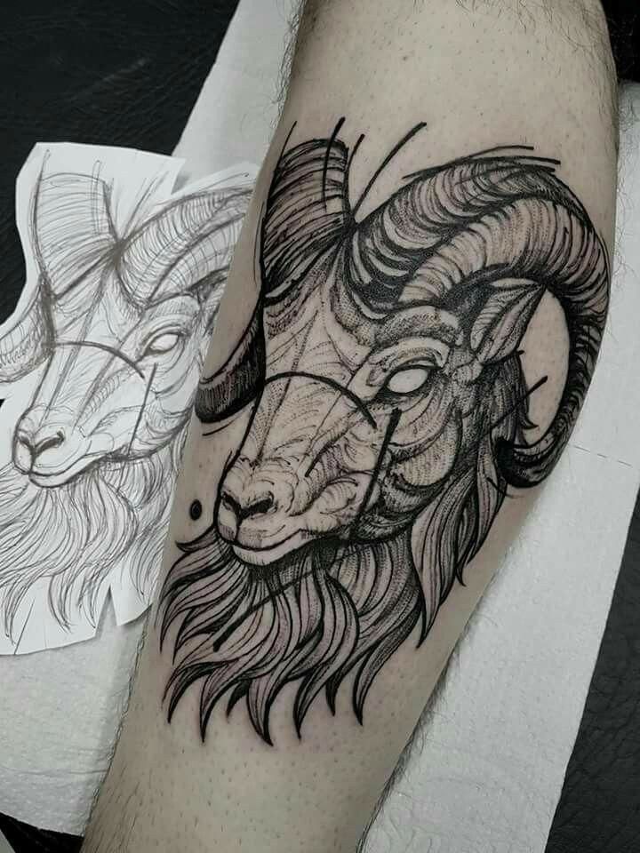 a man's arm with a goat and ram tattoo on it