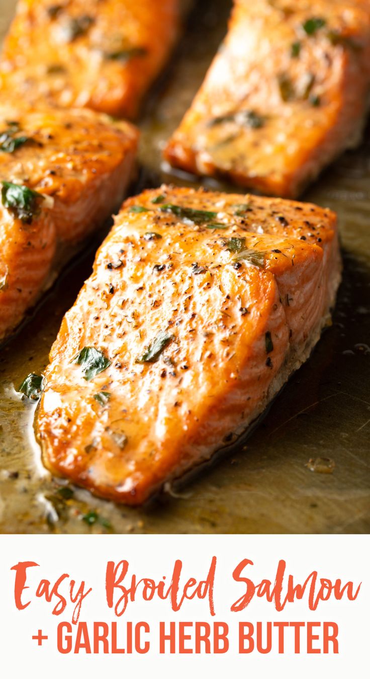 four pieces of cooked salmon sitting on top of a metal pan covered in seasoning