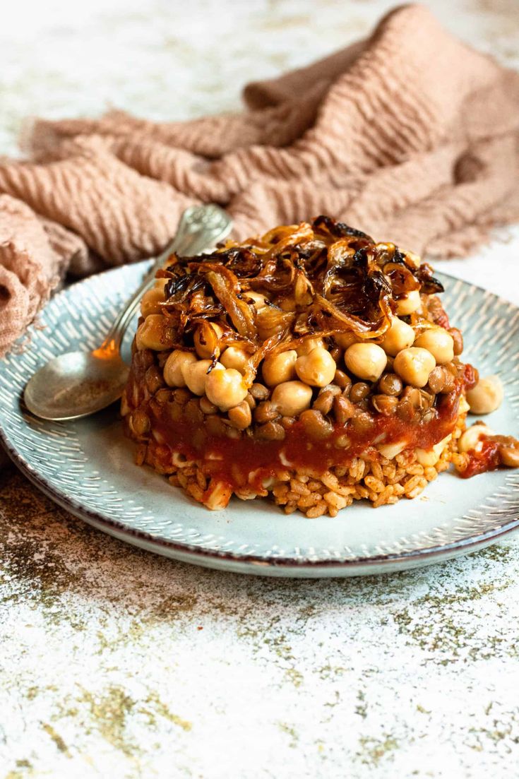 a white plate topped with rice covered in sauce and beans