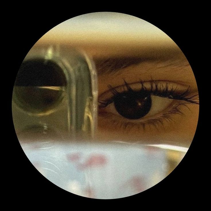 a woman's eye is seen through the reflection of an object in front of her