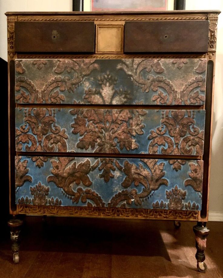 an old dresser with blue and brown paint on it