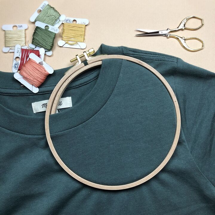 a t - shirt is being sewn and some scissors are laying next to it