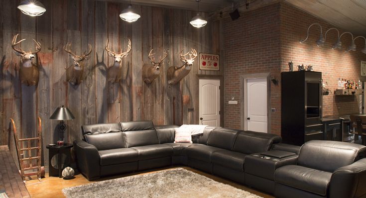 a living room with leather furniture and deer heads on the wall