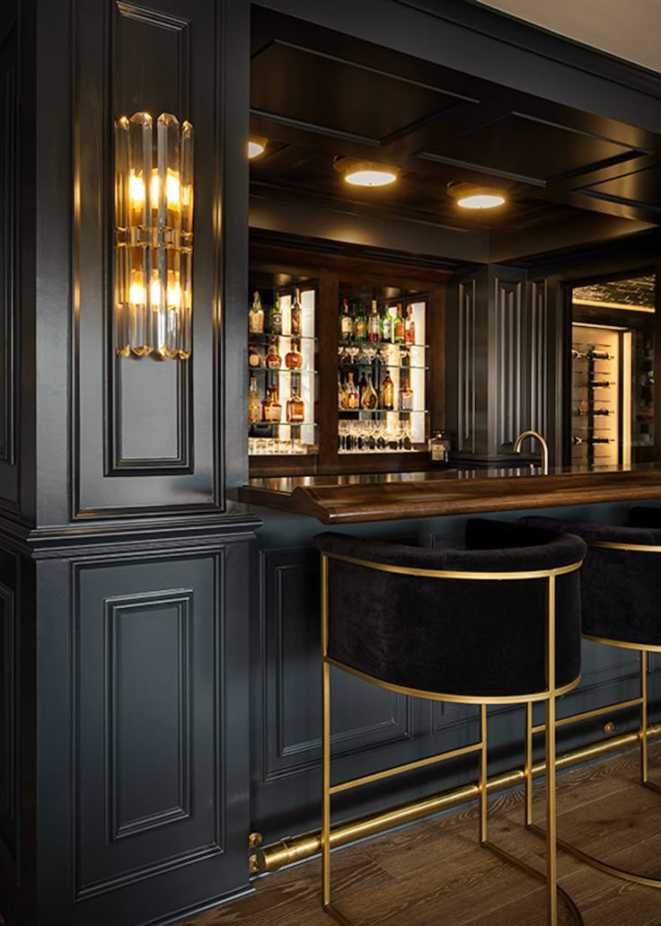 an elegant bar with black velvet stools and gold barstools in the corner