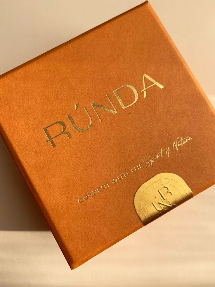 an open book with the word runda written in gold foil on it's cover