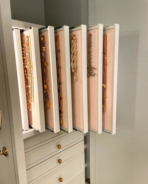 a white cabinet filled with lots of gold jewelry