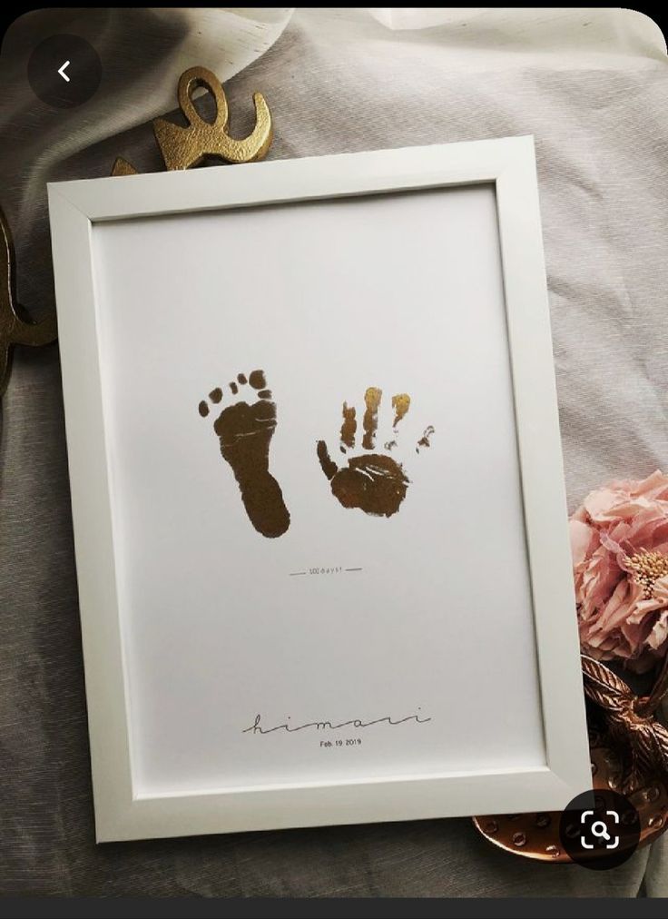 a baby's hand and foot print in a white frame