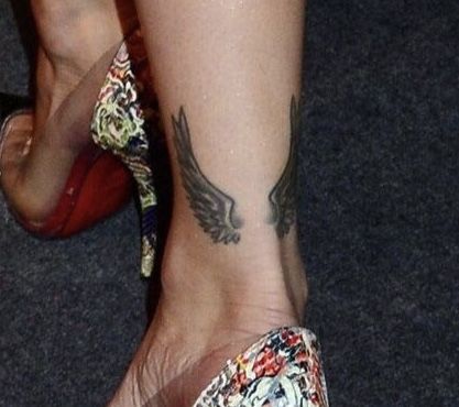 a woman's feet with tattoos and high heels