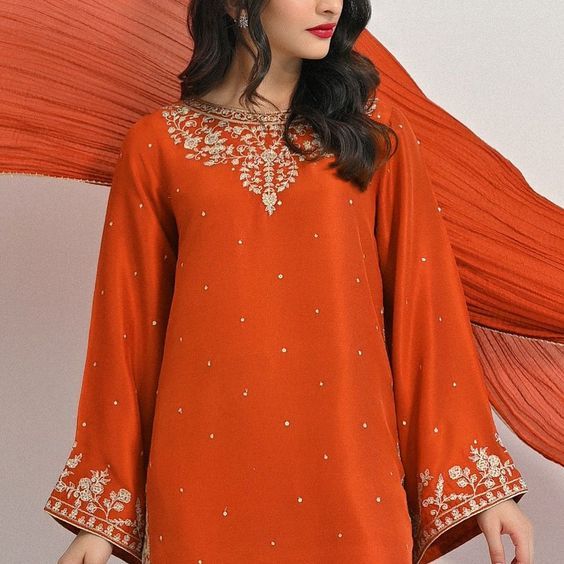 Meticulously crafted from a remarkably glamourous shade of burnt orange ( pure raw silk 58 Gms )“ Minaree “ with its intricate zari details strikes the perfect balance between elegant and eye-catching, making this beautiful design a must have. The length of the long kameez is 46 inches.Agha Noor’s style tip - “ Style w Naqshi Raw Silk Traditional Wear For Party, Red Raw Silk Traditional Wear With Naqshi, Elegant Red Kurta With Naqshi Detailing, Elegant Red Kurta With Naqshi, Gold Silk Dupatta With Naqshi, Elegant Traditional Wear With Dabka In Art Silk, Designer Wear Orange Dupatta With Intricate Embroidery, Designer Orange Dupatta With Intricate Embroidery, Elegant Raw Silk Kurta For Festivals