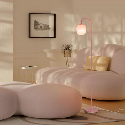 a living room filled with white furniture and a pink lamp on top of a table