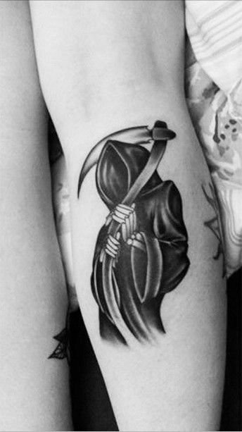 a woman's leg with a tattoo on it and a skull holding a knife