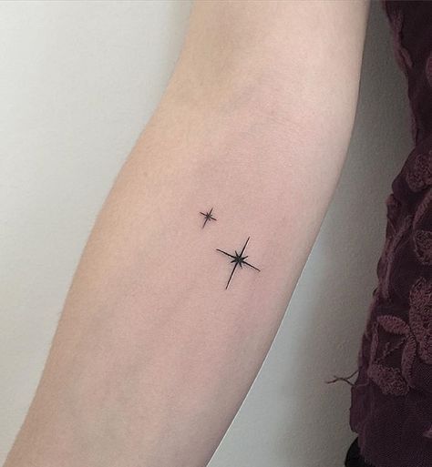 a small star tattoo on the arm